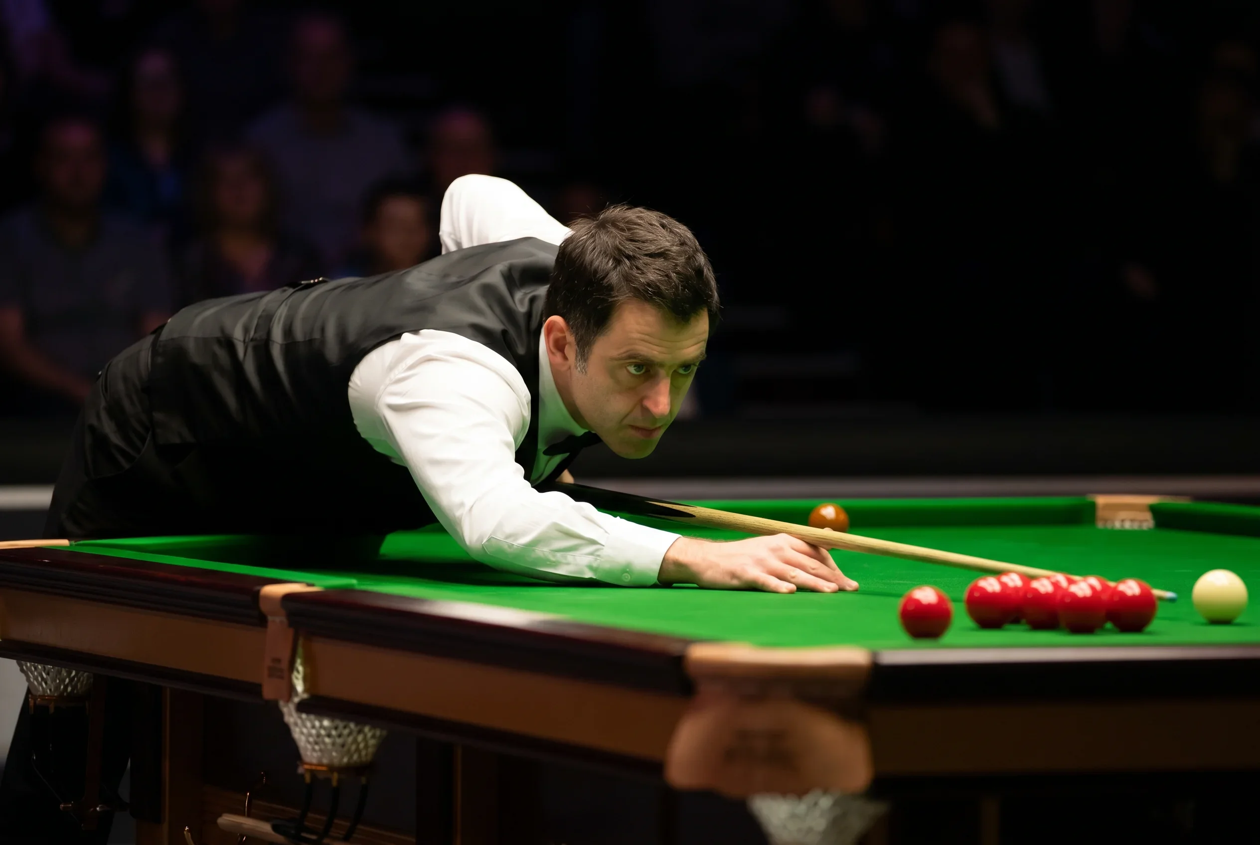 Profi-Snookerspieler am Tisch während eines Live-Matches mit präzisem Queue-Stoß
