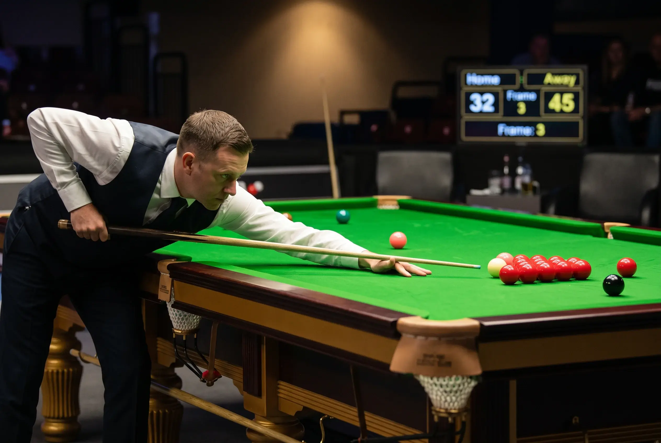 Snookerspieler beim präzisen Stoß am Profitisch mit Scoreboard im Hintergrund