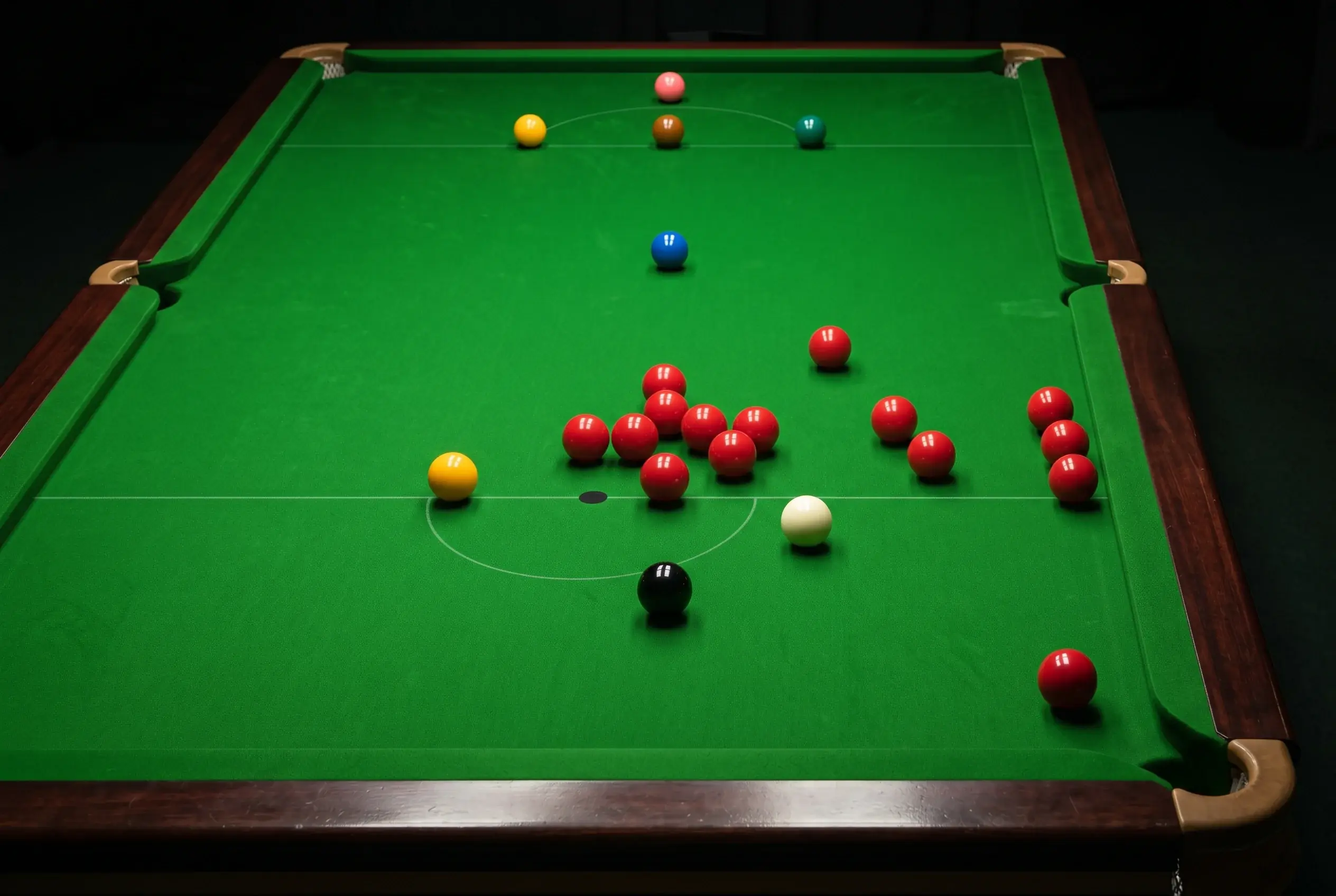 Snooker-Tisch mit roten und farbigen Bällen in Spielposition während eines Frames