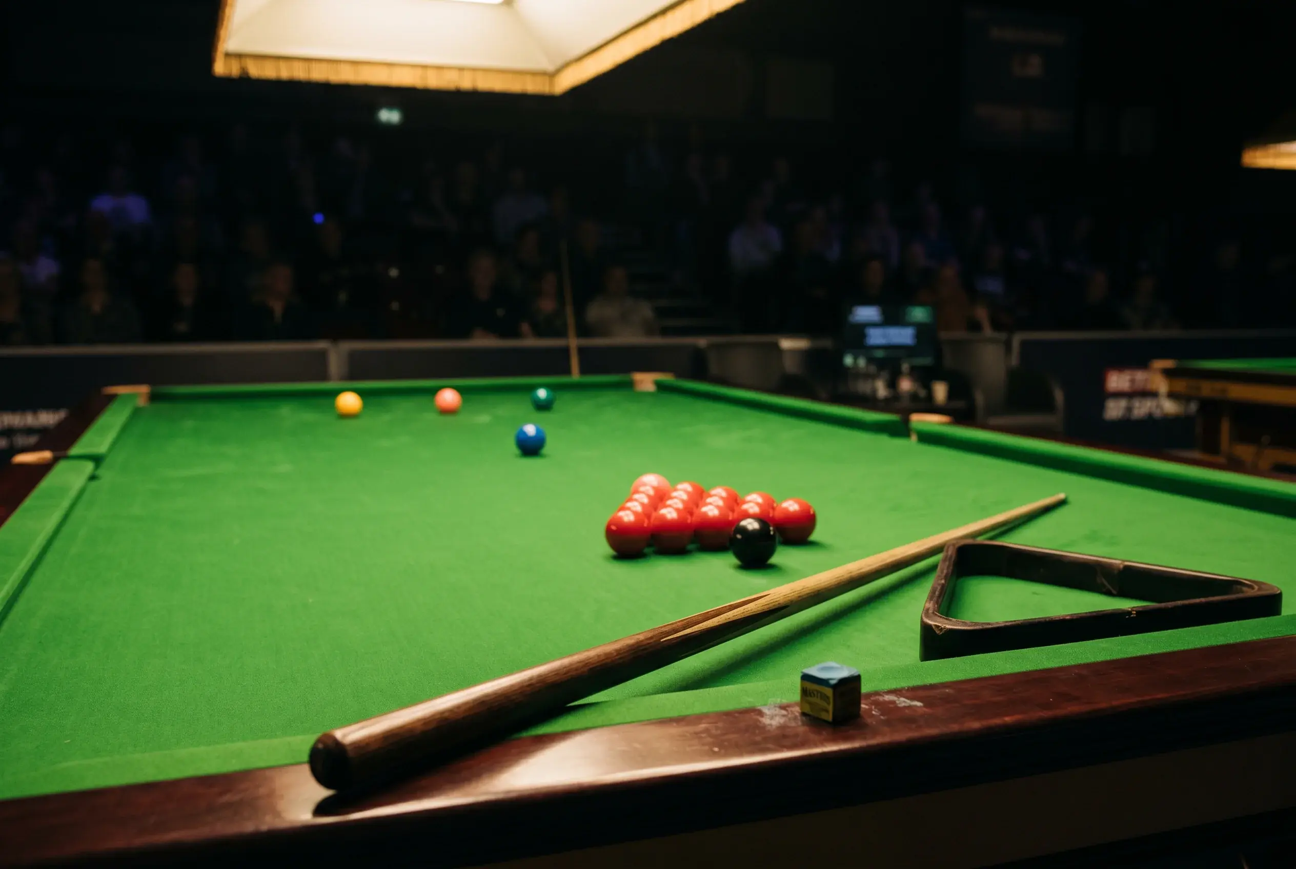 Snooker Wettanbieter Bonus — professioneller Snookertisch mit Queue und Kreide in einem Turniersaal